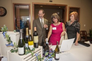 Stephen Young, Kathy Kremer, and Kathleen Dailey, check out the “Wines of the World” raffle prize.