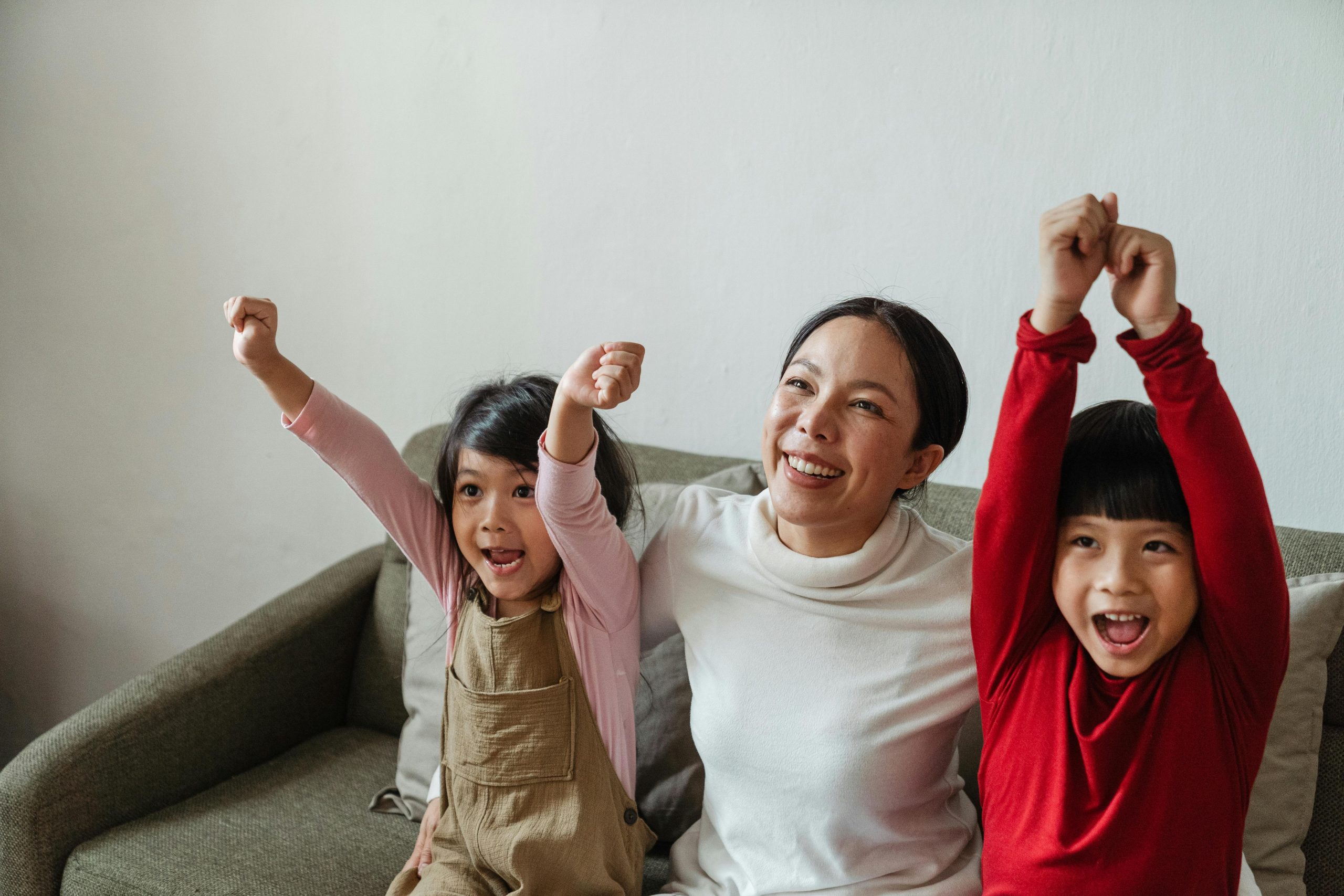 Mother and two children looking joyful.